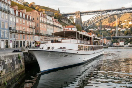 Bateau de croisière amarré sur le Douro à Porto avec le pont Dom Luís I en arrière-plan en automne