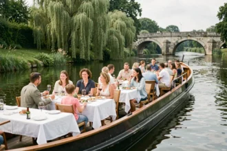 Croisière repas sur la Mayenne avec passagers attablés sur le pont d'une péniche traditionnelle en France