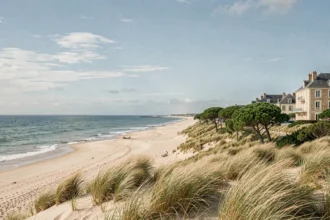 Paysage côtier de la Vendée avec plage de sable, dunes et architecture hôtelière en arrière-plan