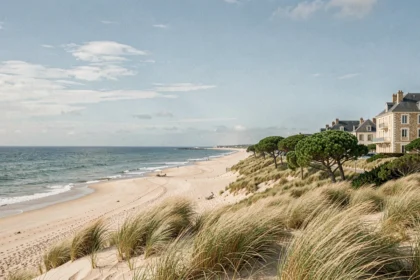 Paysage côtier de la Vendée avec plage de sable, dunes et architecture hôtelière en arrière-plan