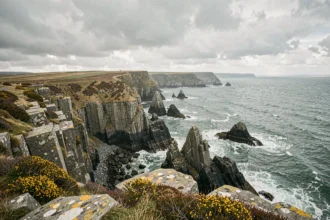 Pointe de Kadoran en Bretagne avec falaises de granit noir et mer agitée sous un ciel nuageux